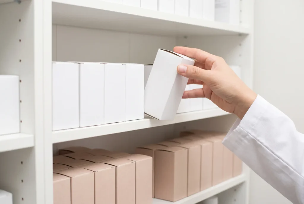 A doctor taking a box of medication from the dispensary shelves at the Koh Phi Phi clinic